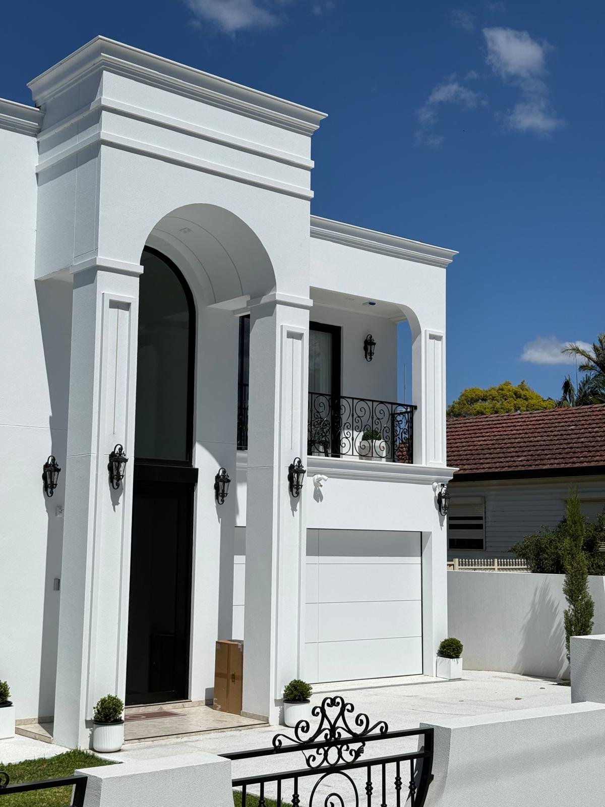 Double-height arched entrance and decorative balcony ironwork